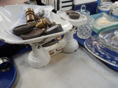 A white enamel kitchen scale and various weights.