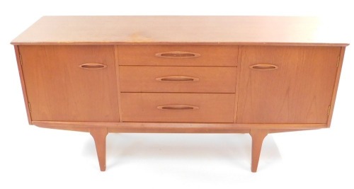 A mid century teak sideboard, with three central drawers, flanked by a pair of cupboard doors, raised on tapering square legs, 73cm high, 152cm wide, 44cm deep.