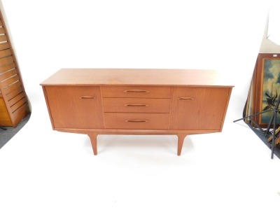A mid century teak sideboard, with three central drawers, flanked by a pair of cupboard doors, raised on tapering square legs, 73cm high, 152cm wide, 44cm deep. - 2