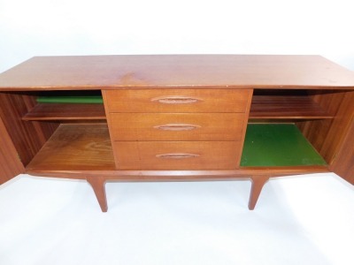 A mid century teak sideboard, with three central drawers, flanked by a pair of cupboard doors, raised on tapering square legs, 73cm high, 152cm wide, 44cm deep. - 4