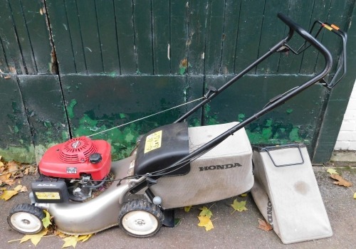 A Honda Izy petrol lawn mower, GCV135 with basket.