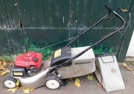 A Honda Izy petrol lawn mower, GCV135 with basket.