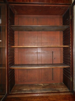 A Victorian mahogany library bookcase, the out swept pediment over two pairs of glazed doors, each opening to reveal three shelves, above four cupboard doors, raised on a plinth base, 244cm high, 196cm wide, 45.5cm deep. - 4