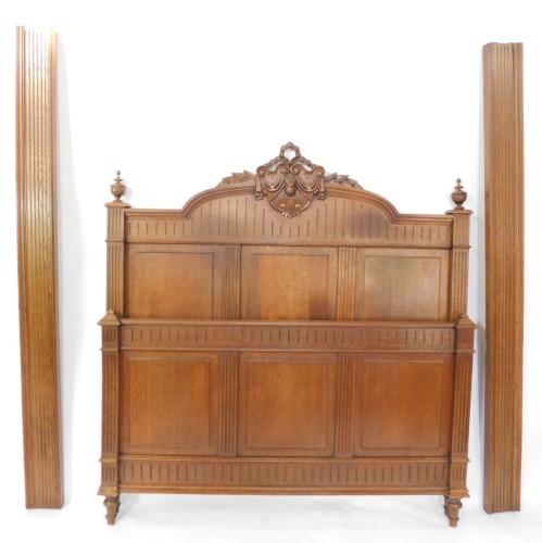A Victorian oak double bed, with carved headboard, and wooden side planks.