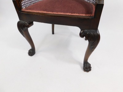 A Georgian style mahogany Bergere chair, early 20thC, with cane back and overstuffed seat, raised on leaf carved cabriole legs, and hairy paw feet. - 3