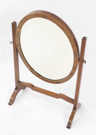 An Edwardian mahogany and box wood line inlaid oval swing frame toilet mirror, inset bevelled glass, 67cm high, 43.5cm wide.