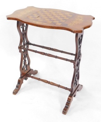 A Victorian walnut and inlaid serpentine games table, with chequer board top, raised on carved vase shaped ends, united by turned stretchers, 67cm high, 59.5cm wide, 38cm deep.