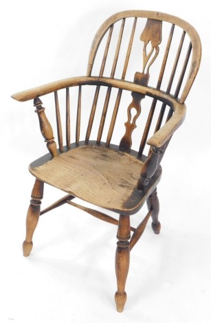 A 19thC oak and elm Windsor chair, with a carved shaped splat, solid saddle seat, raised on turned legs united by an H frame stretcher.