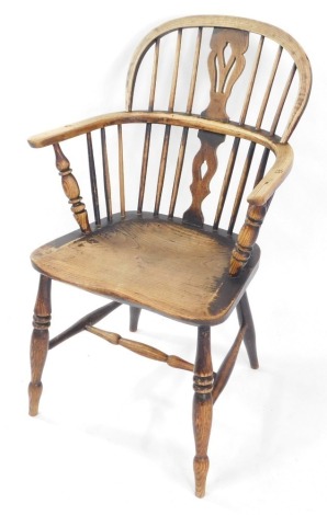 A 19thC oak and elm Windsor chair, with a carved shaped splat, solid saddle seat, raised on turned legs united by an H frame stretcher.