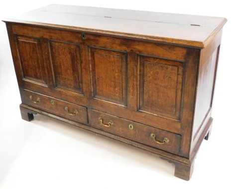 An 18thC oak mule chest, the hinged lid opening to reveal a candle tray above a pair of frieze drawers, the four paneled front over a pair of drawers, raised on bracket feet, 46cm high, 141cm wide, 52.5cm deep.