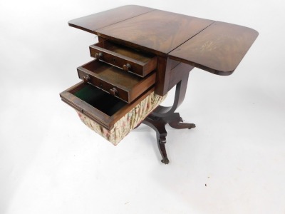 A Victorian flame mahogany drum sewing table, the drop leaf top above two frieze drawers, and a linen bound drum, raised on a U shaped support, above a quatrefoil base, over out swept legs, brass paw capped on castors, 67.5cm high, 36cm wide, 74cm extende - 3