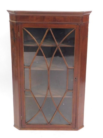 A mahogany wall hanging corner cupboard, the out swept pediment over a glazed door, enclosing three shelves, made up, 102.5cm high, 65cm wide, 37cm deep.