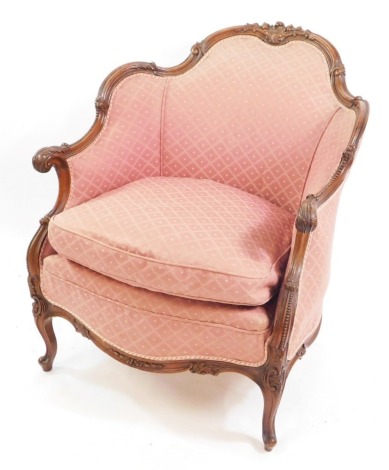 A French Louis XV style mahogany fauteuil, with foliate carving, upholstered in red patterned fabric, loose cushion seat, raised on cabriole legs.