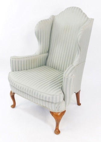 A George I style mahogany wingback armchair, upholstered in turquoise striped fabric, raised on cabriole legs.