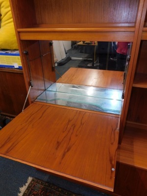 A G-Plan 1960's teak lounge unit, the two section top with an arrangement of five shelves and a drop down drinks cabinet, above a sideboard base with four doors, raised on a plinth base, 198cm high, 162.5cm wide, 46cm deep. - 4