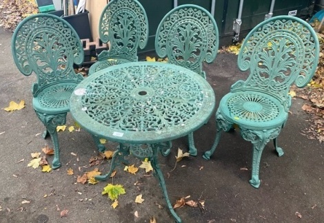 A green metal garden table, with wire scroll detailing, cast, with four matching chairs.