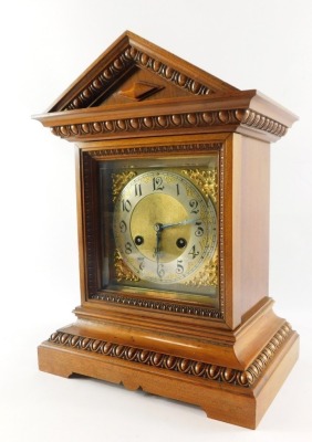 A Junghans late 19thC oak cased mantel clock, the brass dial with silvered chapter ring bearing Arabic numerals, eight day movement with coil strike, the case of architectural form with egg and dart moulding, raised on bracket feet, with key, 37.5cm high,