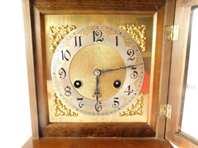 A Junghans late 19thC oak cased mantel clock, the brass dial with silvered chapter ring bearing Arabic numerals, eight day movement with coil strike, the case of architectural form with egg and dart moulding, raised on bracket feet, with key, 37.5cm high, - 2