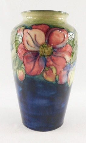 A Moorcroft pottery vase decorated in the Clematic pattern, against a green ground, painted and impressed marks, 21cm high.