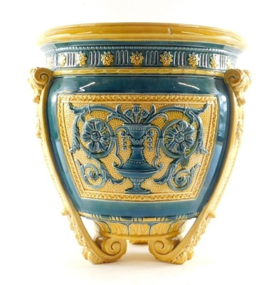 A Wedgwood late 19thC blue and yellow pottery jardiniere, moulded with panels of classical vases, flowers and foliate scrolls, raised on three leaf moulded scroll feet, impressed and painted marks, 34cm high, 32cm wide. (AF) - 2