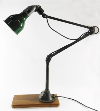 A 1920's Mek Elek anglepoise industrial lamp, with green shade and metal fittings, on a wooden base, approx 85cm high when shortened, approx 130cm high when fully extended.