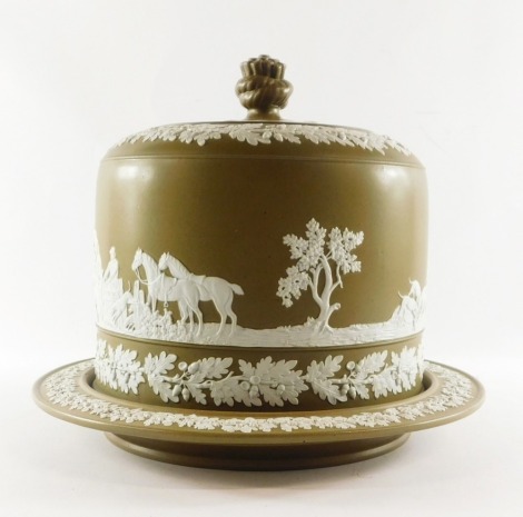 A late 19thC brown stoneware stilton dish and cover, with a rope knot finial finial top, sprig moulded with a hunting scene and bands of acorns, 28cm high, 31cm wide.