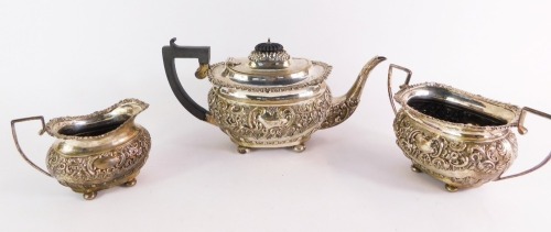 An Edward VII silver three piece tea set, embossed with rococo scrolls and flowers, comprising tea pot, milk jug and sugar bowl, George Nathan & Ridley Hayes, Chester 1902, 36oz gross.