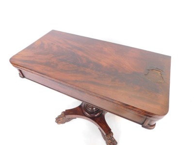 A Regency mahogany fold over card table, with canted corners, opening to reveal a red lined table interior, on a lappet carved column and quatrefoil base, on lion's paw feet, 71.5cm high, 91cm wide, 44cm deep. (AF) - 2