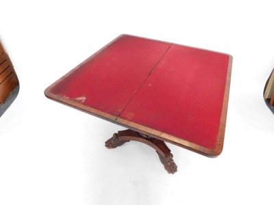 A Regency mahogany fold over card table, with canted corners, opening to reveal a red lined table interior, on a lappet carved column and quatrefoil base, on lion's paw feet, 71.5cm high, 91cm wide, 44cm deep. (AF) - 3