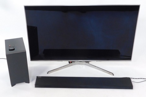 A Panasonic 50" flat screen television, in chromed outer finish, with sound bar and Panasonic sound box, with remote control.