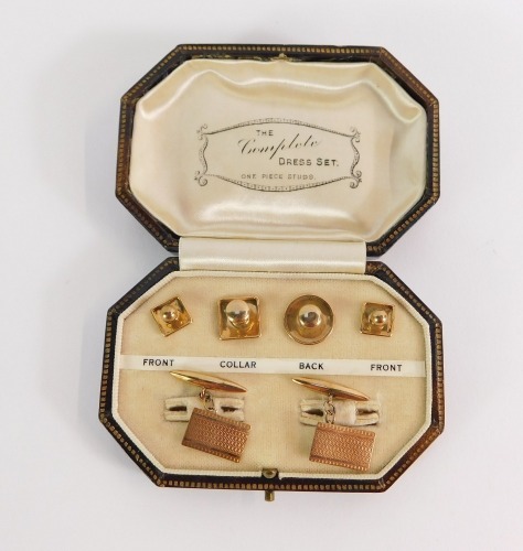 A 9ct gold cased gentleman's set, comprising a pair of rectangular engine turned cuff links, and four collar studs, in fitted case, marked The Complete Dress Set, 4.9g.