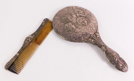 A George V silver dressing table set, comprising a silver backed hand mirror embossed with five cherub's heads, Birmingham 1911, together with a silver mounted tortoiseshell comb, Chester. (2, AF)