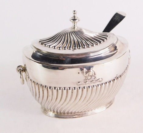 A Victorian silver sugar box and matched spoon, for The Worshipful Company of Grocers, of Adam oval form, with semi spiral fluting and embossed with the crest of a camel above a motto 'God Grant Grace', London 1896, spoon bearing initials JML, London 1921