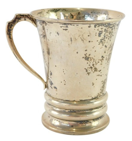 A silver christening tankard, with a shaped and flared handle, on a two collared base, hallmarks rubbed, 3¼oz.