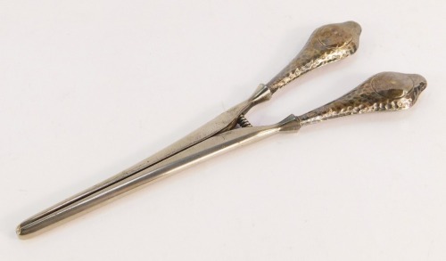A pair of George V silver handled glove stretchers, the handles with vacant shield crest and hammered detailing, Chester 1924, with stainless blades, 2¾oz gross.