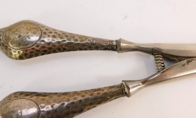 A pair of George V silver handled glove stretchers, the handles with vacant shield crest and hammered detailing, Chester 1924, with stainless blades, 2¾oz gross. - 2