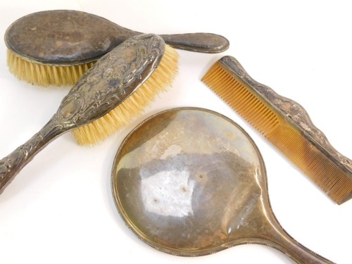 A silver dressing table set, comprising a George V silver hand mirror and brush, with channeled detailing, Birmingham 1922, together with a later silver comb and a silver cherub embossed hairbrush. (4)