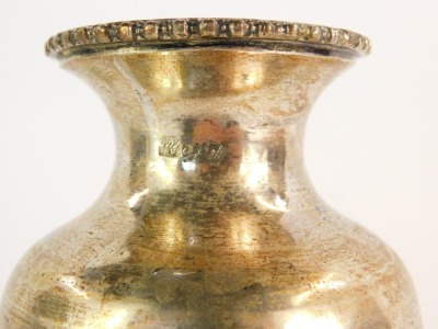 An Eastern vase of baluster form, repousse decorated with four reserves of flowers, white metal, 17cm high, 9½oz. - 2