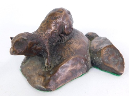 M W Pierce. A bronzed figure of an otter, modelled on a river bank, 8cm wide, on cushioned base.