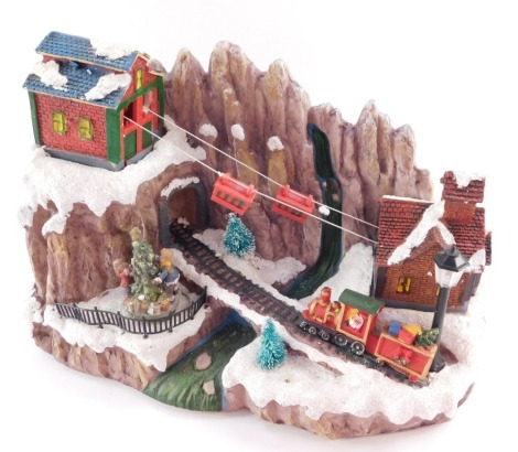 A Christmas musical figure group, on a plastic moulded base, with train and cart figures, 22cm high, 30cm wide.