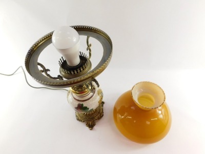 A 20thC oil lamp style electric table lamp, with orange glass shade on a brass three prong support, with glazed and floral print body on rococo foot, 52cm high. WARNING! This lot contains untested or unsafe electrical items. It is supplied for scrap or r - 4