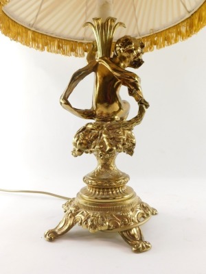 A continental brass cherub table lamp, the stem with putto holding a flower, on a floral seated base, with four out splayed legs, with orange shade, 64cm high. - 3