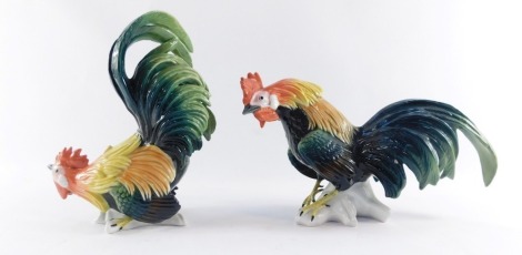 Two Karl Ens cockerel figures, one perched looking up, the other on a stump looking down, printed marks, 23cm high and 18cm high respectively. (2)
