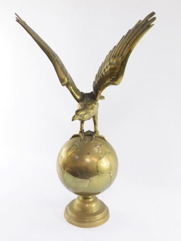 A mid 20thC brass figure group, of an eagle perched on globe, on a stepped base, 65cm high.