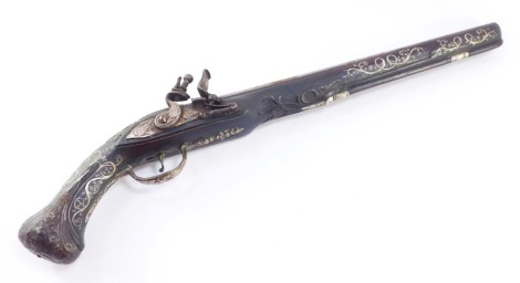 An Ottoman Empire flintlock pistol, with an engraved steel barrel, the moulded stock with silver wire inlay, 50cm long.