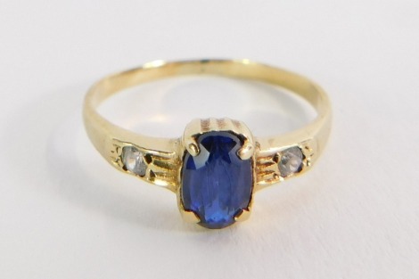 A sapphire and diamond set dress ring, the rectangular cut sapphire in four claw rub over setting, with two tiny diamond set shoulders, on a yellow metal band, stamped 10K, size J½, 1.4g all in, boxed.