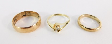 Three bands, comprising a 9ct gold wedding band of plain design, 2.8g, a two stone diamond dress ring, yellow metal, stamped 585, and another band, unmarked, 4.4g all in.