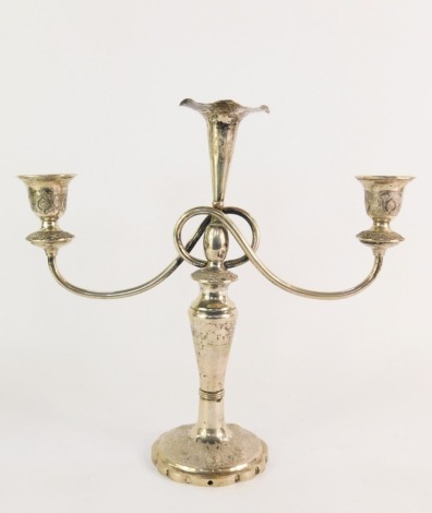 An Eastern candelabrum, with three branch sconce, embossed and engraved floral detailing on a circular fluted base, white metal, bears marks, 31cm high, 24½oz.