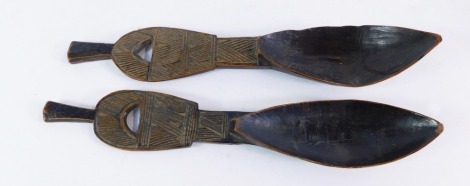 Two carved ethnographic wooden spoons, each with hatch design top and large oblong bowl, 25cm long.