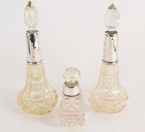 A pair of cut glass scent bottles and stoppers, with silver mounts, and a further scent bottle and stopper, with silver mount, hallmarks worn. (3)